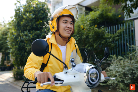 smiling rider on yellow scooter