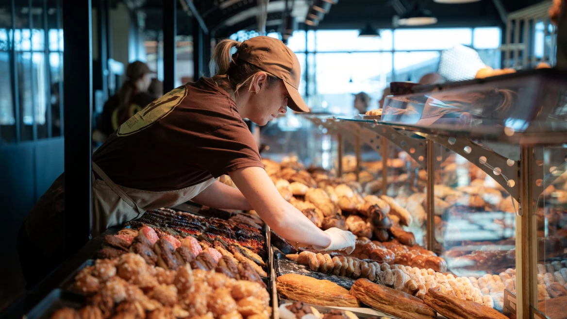 employée de boulangerie en vitrine de viennoiseries