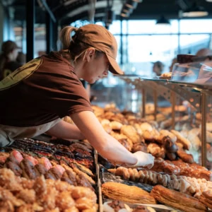 employée de boulangerie en vitrine de viennoiseries