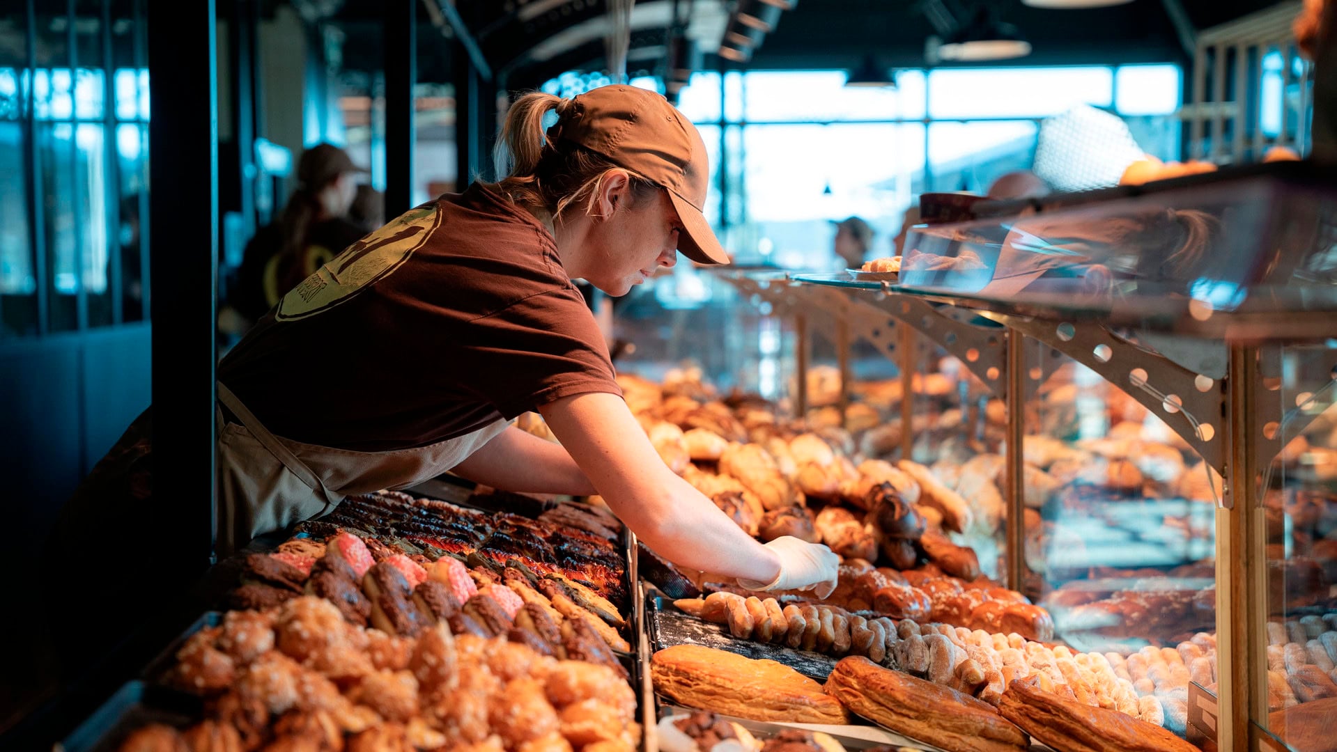 employée de boulangerie en vitrine de viennoiseries