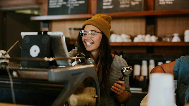 barista souriante dans un café chaleureux