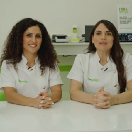 due donne presentano cosmetici in studio bianco