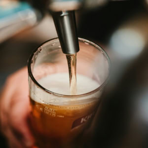 beer pouring into a glass with golden foam