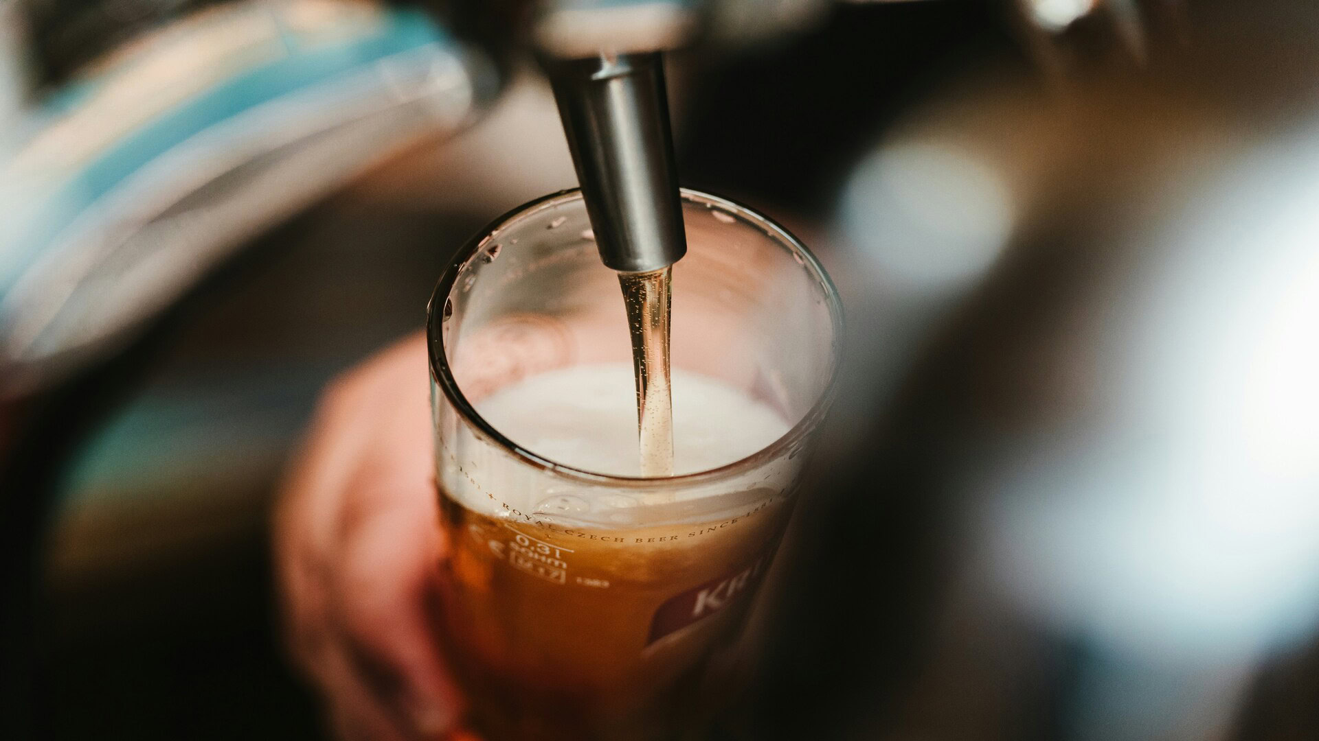 beer pouring into a glass with golden foam