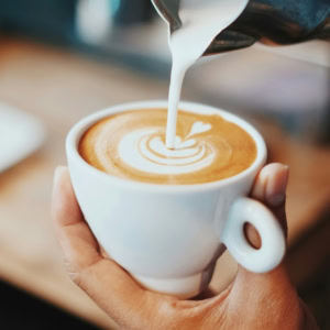 barista verse le lait dans un latte art murénique