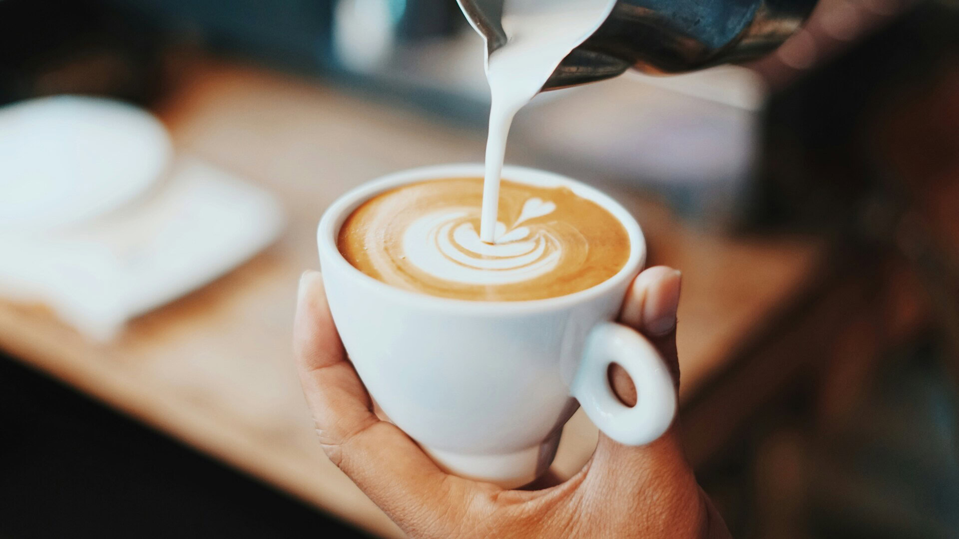 barista verse le lait dans un latte art murénique