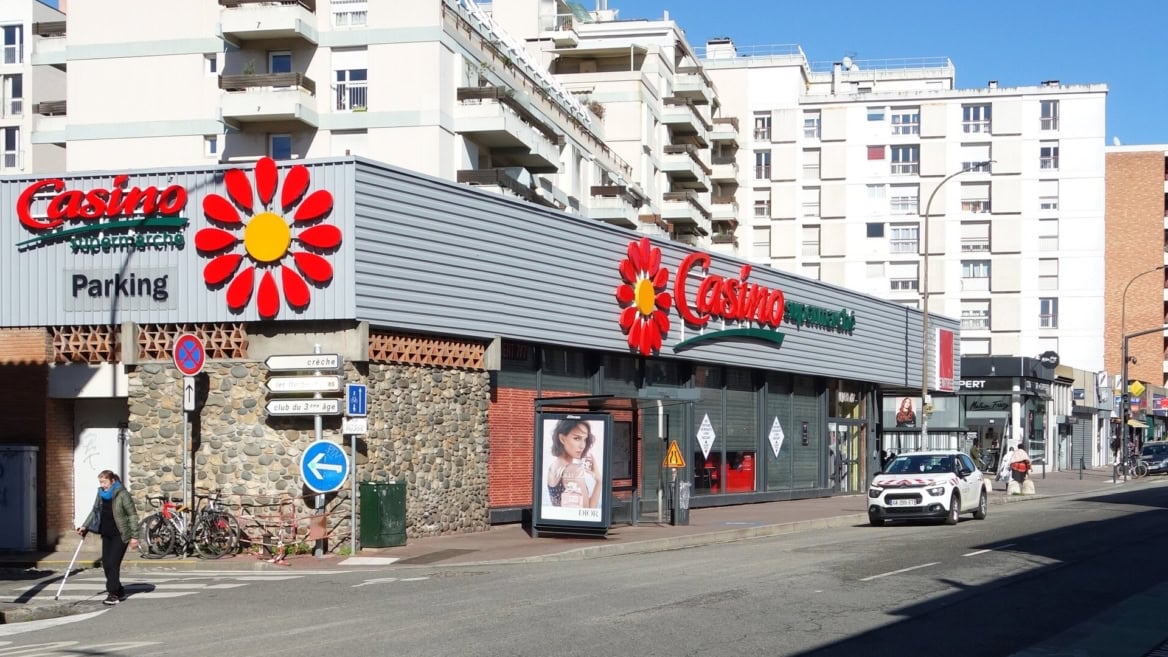 casino supermarché, rue urbaine et immeubles blancs
