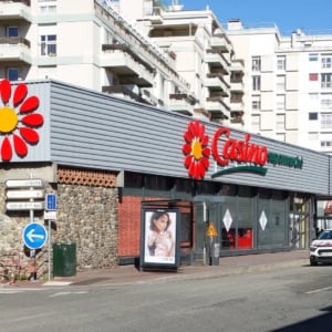 casino supermarché, rue urbaine et immeubles blancs