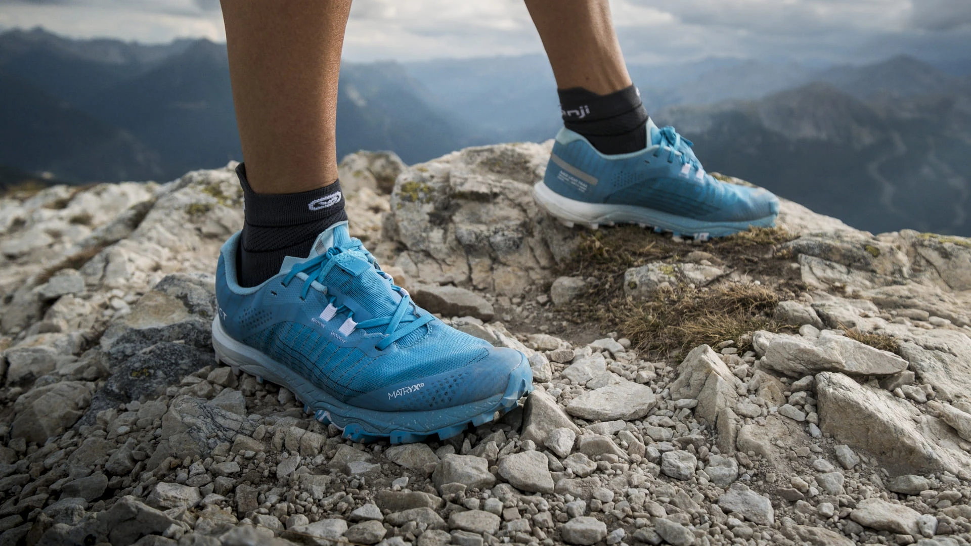 chaussures de trail bleues sur rochers de montagne