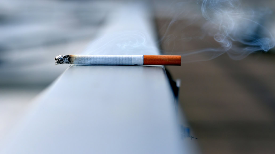 cigarette fumante sur fond flou et sombre
