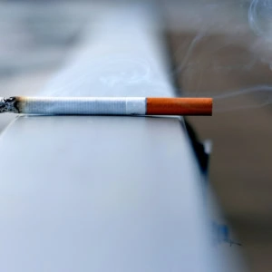 cigarette fumante sur fond flou et sombre