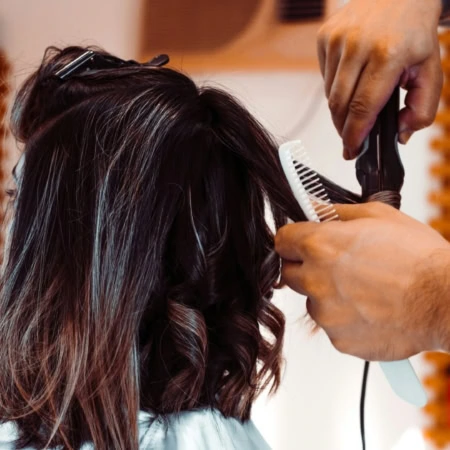 coiffure en salon : boucles sur cheveux bruns