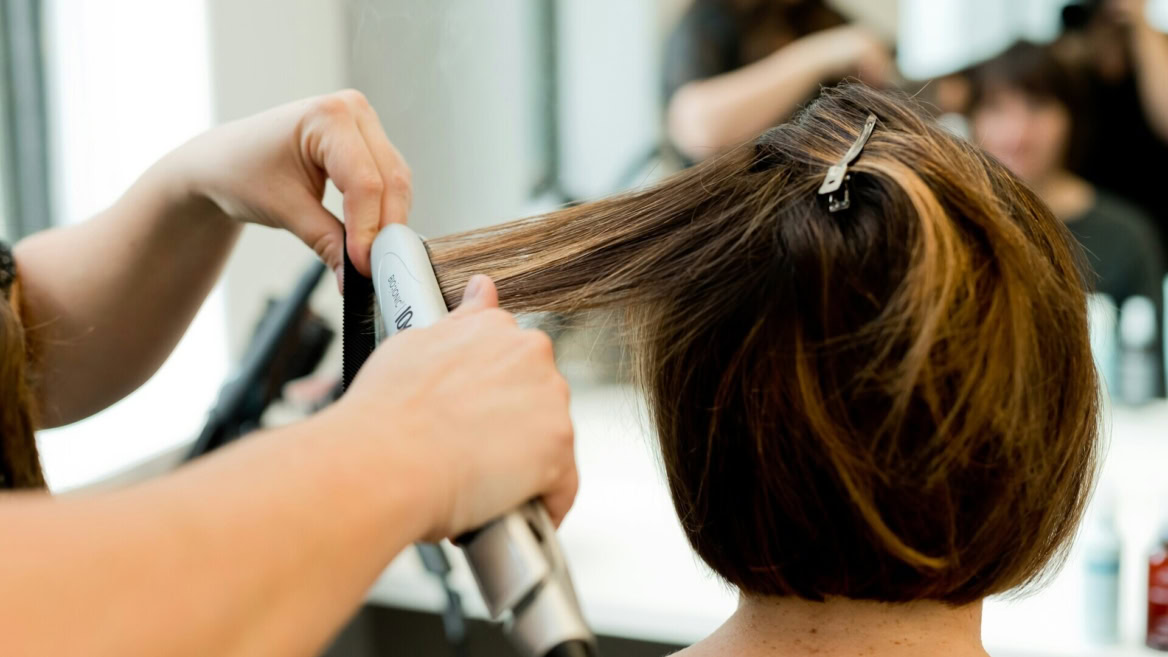 coiffure en salon : fer à lisser sur cheveux courts