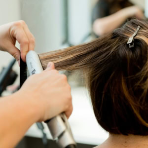 coiffure en salon : fer à lisser sur cheveux courts