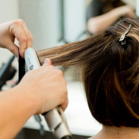 coiffure en salon : fer à lisser sur cheveux courts