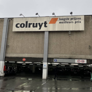supermarché colruyt, façade industrielle sous la pluie