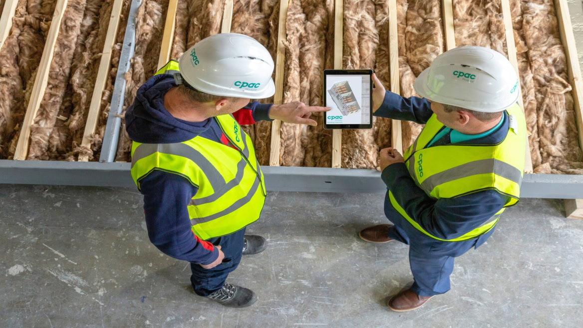 deux ouvriers consultent un plan 3d sur tablette