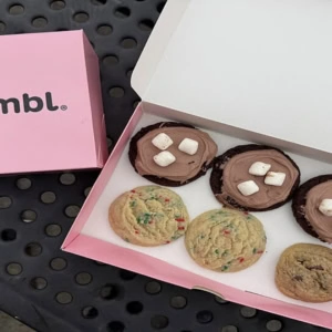 boîtes crumbl roses avec assortiment de cookies