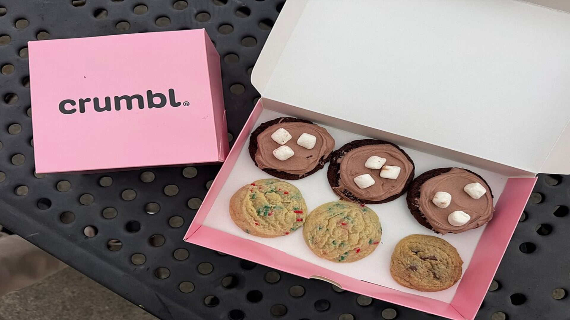 boîtes crumbl roses avec assortiment de cookies