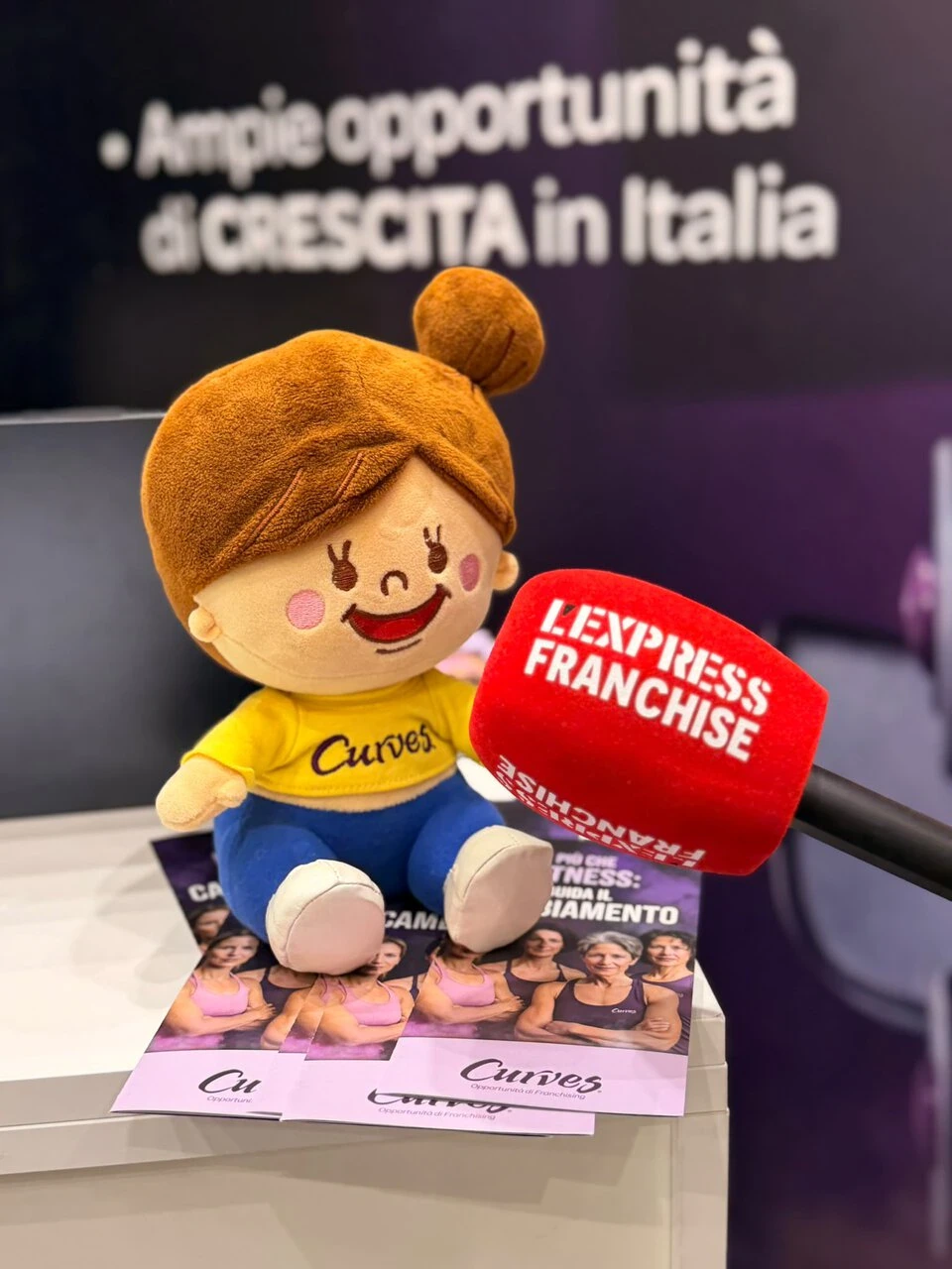 mascotte curves e microfono l’express franchise