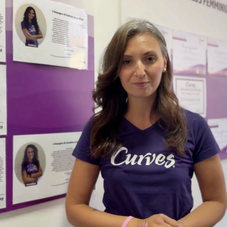 donna curves davanti a poster testimonial fitness