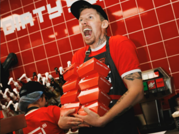 fast food worker carrying a tower of takeaway boxes