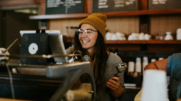barista souriante dans un café chaleureux