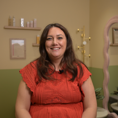 femme souriante en robe corail, salon beauté Élégant