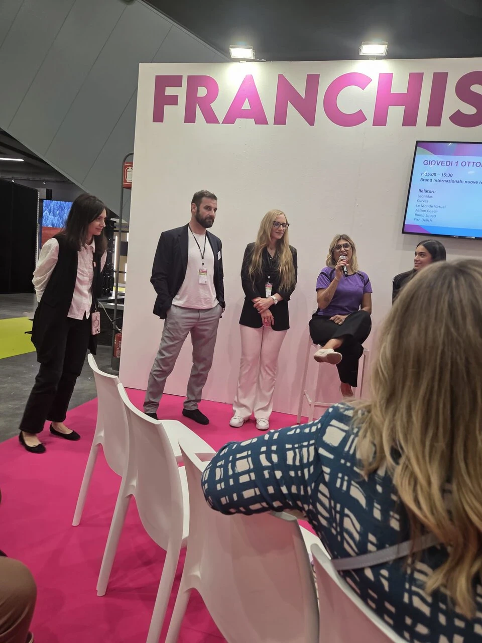 panel franchising al salone, speaker su palco rosa