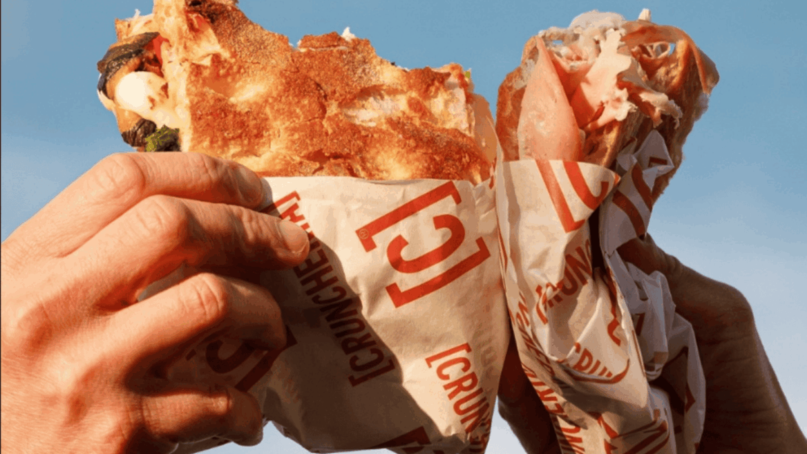 mani con grande kebab avvolto al cielo blu