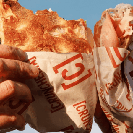 mani con grande kebab avvolto al cielo blu