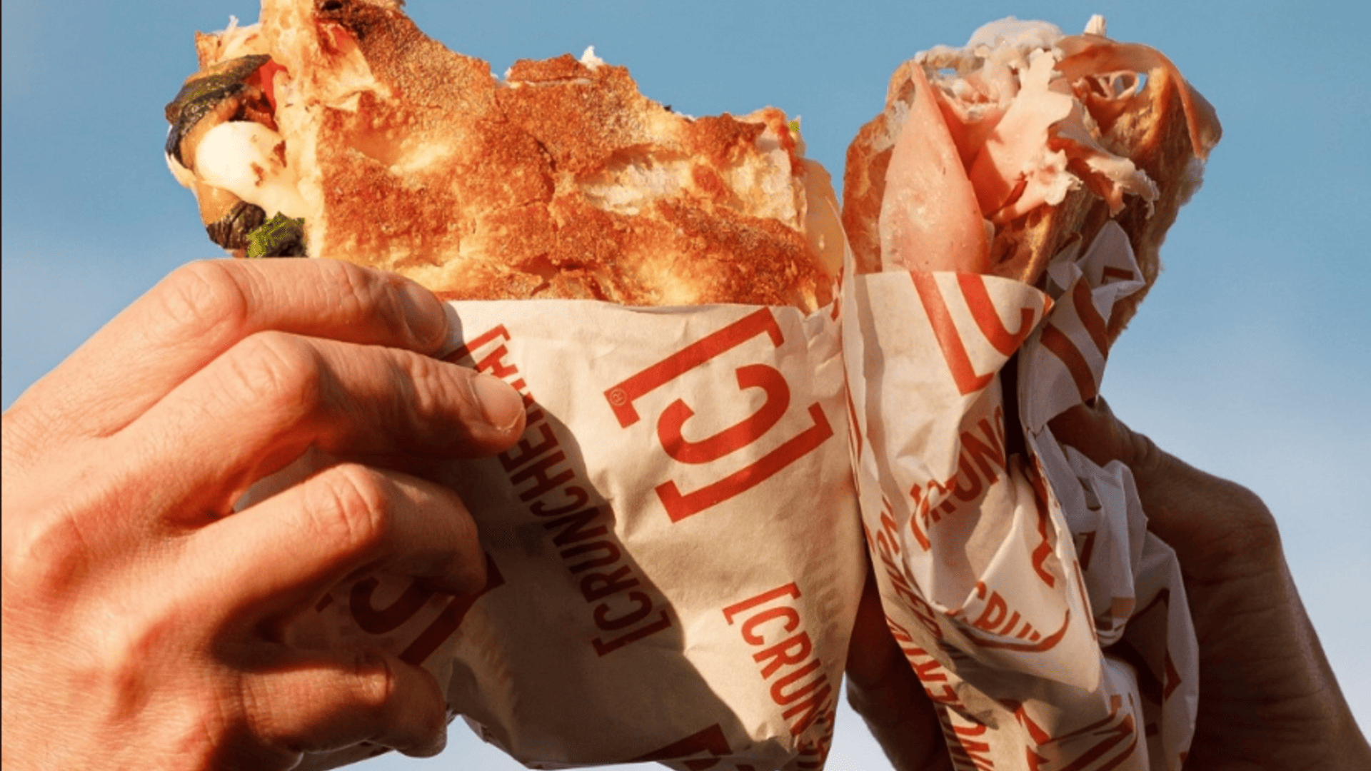 mani con grande kebab avvolto al cielo blu