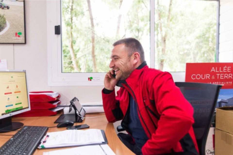 homme souriant au téléphone dans un bureau lumineux