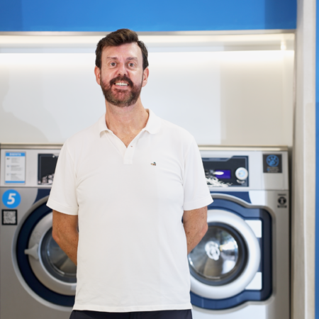 homme dans une laverie moderne avec borne interactive