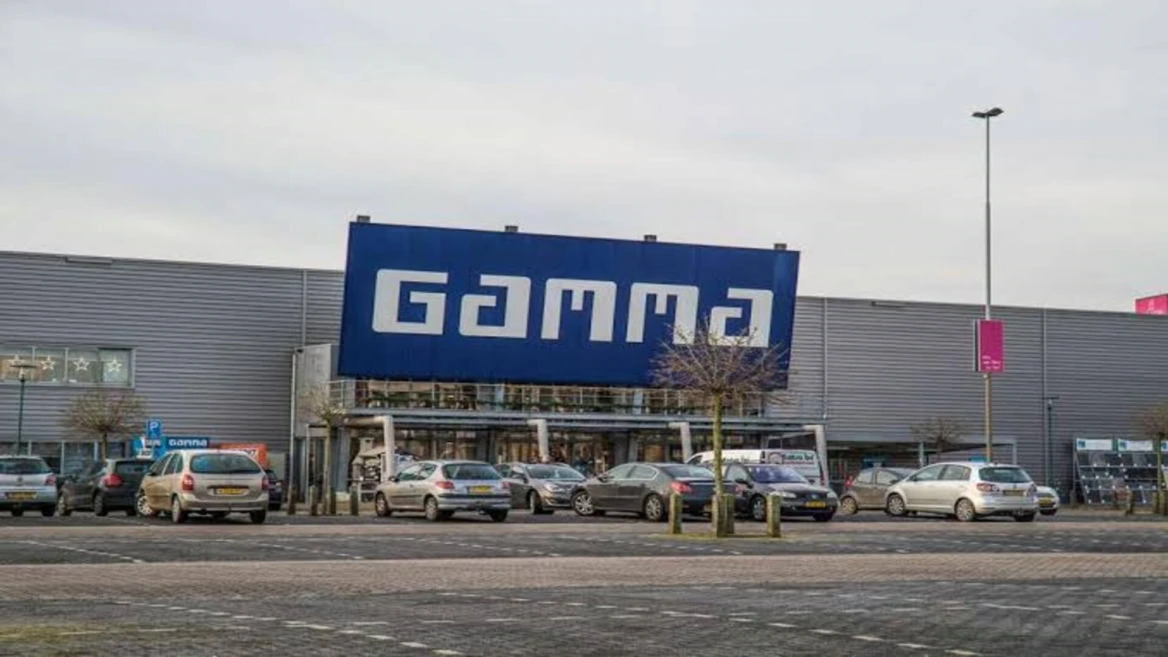 façade du magasin gamma et parking sous ciel gris