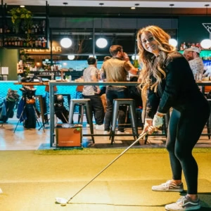 golf practice in a stylish indoor bar