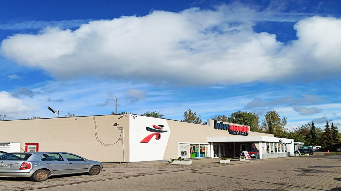 intermarché super : façade et parking sous ciel bleu