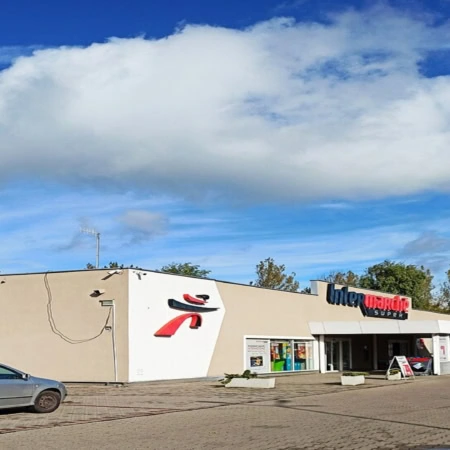 intermarché super : façade et parking sous ciel bleu