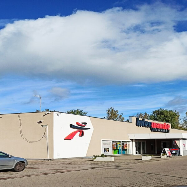 intermarché super : façade et parking sous ciel bleu
