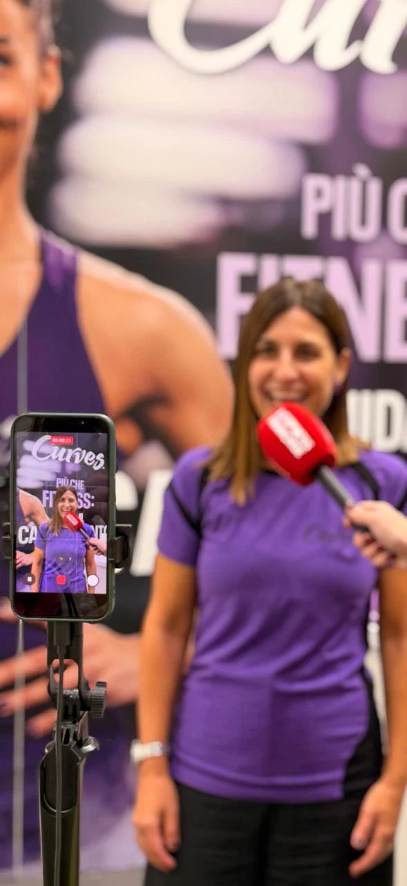intervista fitness: donna, microfono rosso e smartphone