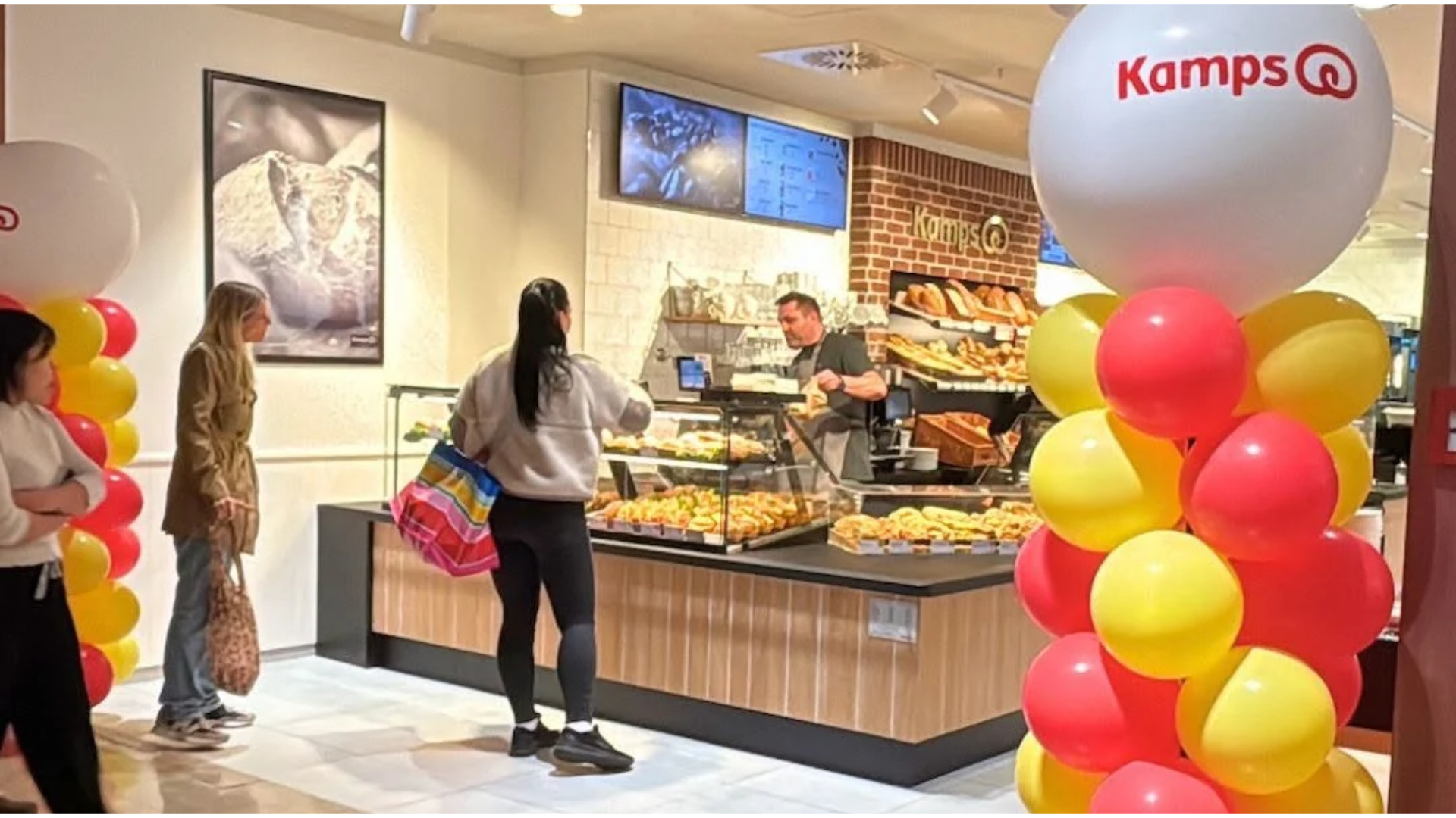 kamps bäckerei eröffnung mit ballons und kunden am tresen
