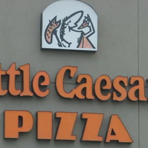 little caesars pizza storefront sign on gray wall