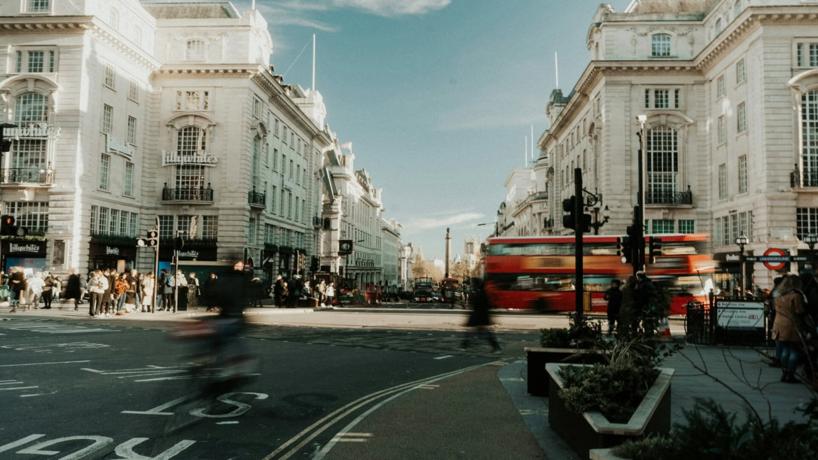 central london intersection with red bus and historic facades