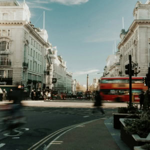 central london intersection with red bus and historic facades