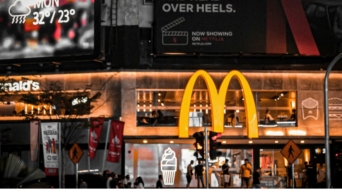 nighttime mcdonald’s with neon city billboards