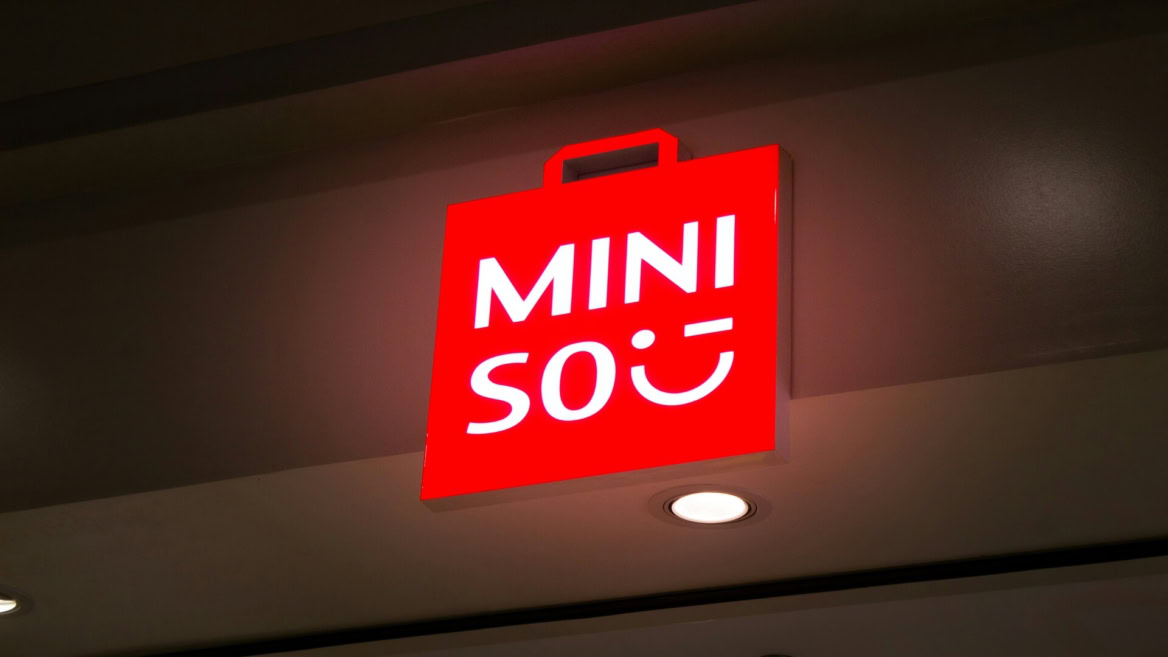 enseigne miniso rouge suspendue au plafond