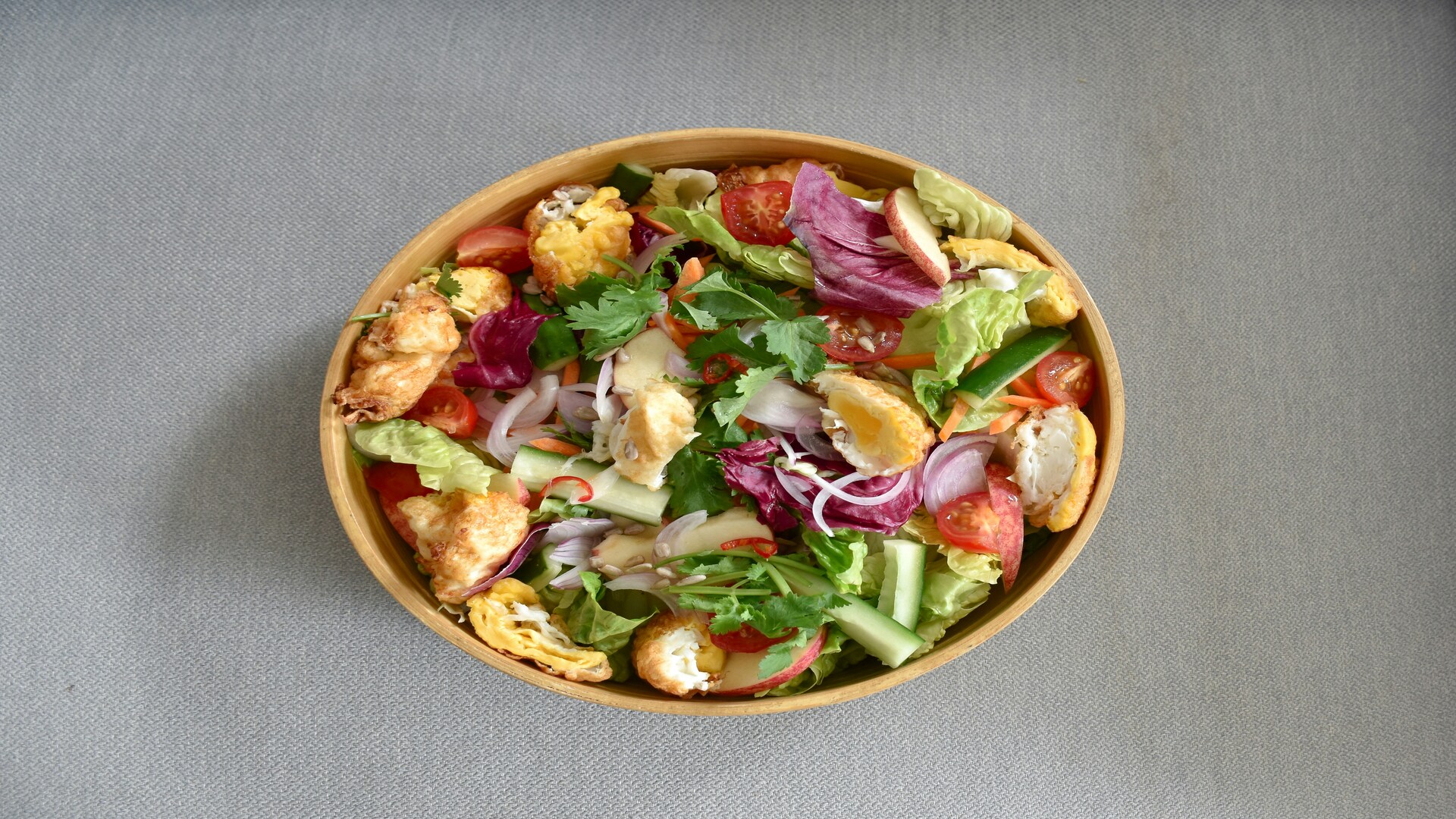 colorful mixed salad in wooden bowl