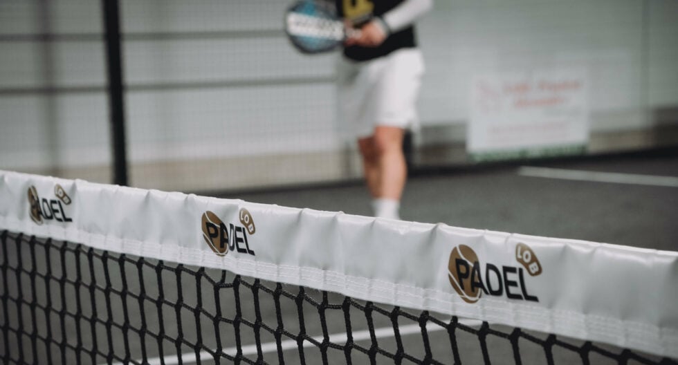 filet de padel indoor, joueur flou en action