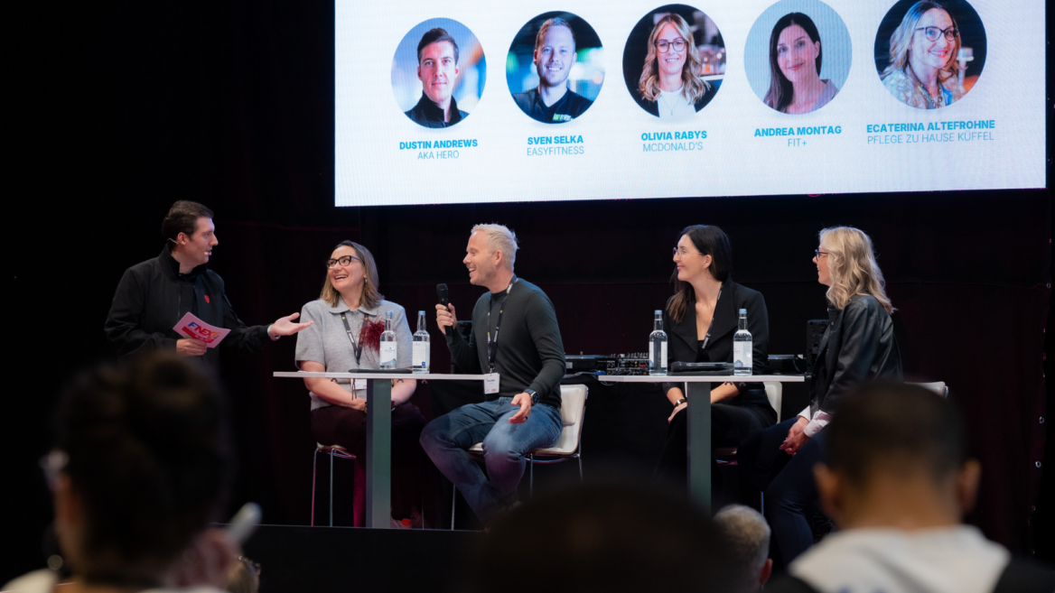 podiumsdiskussion auf der bühne mit fünf speakern