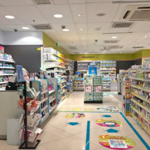 bright pharmacy aisle with cashier and shelves